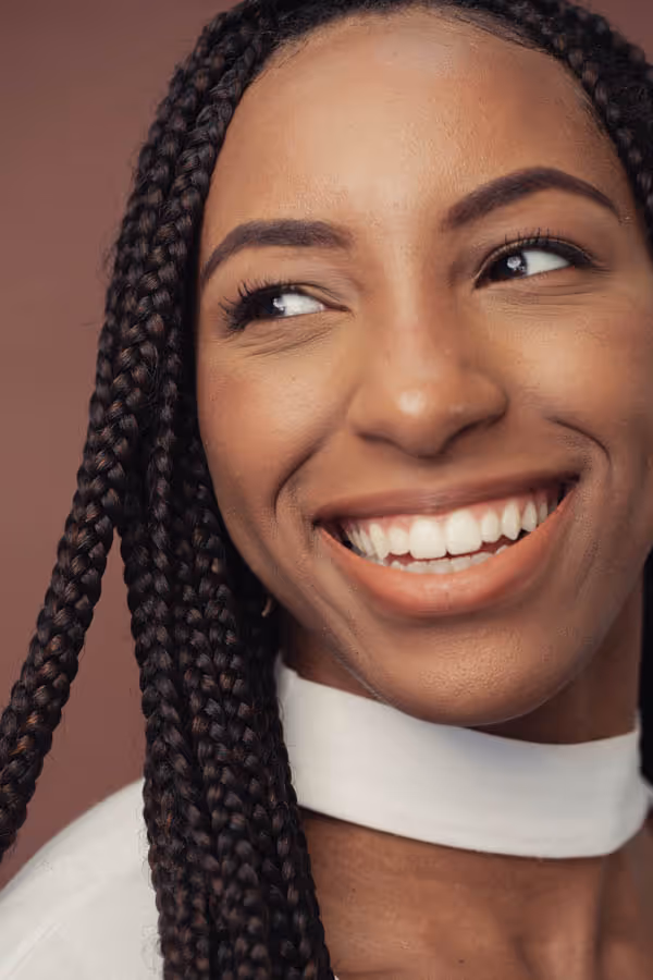 Headshot of a smiling woman with braids