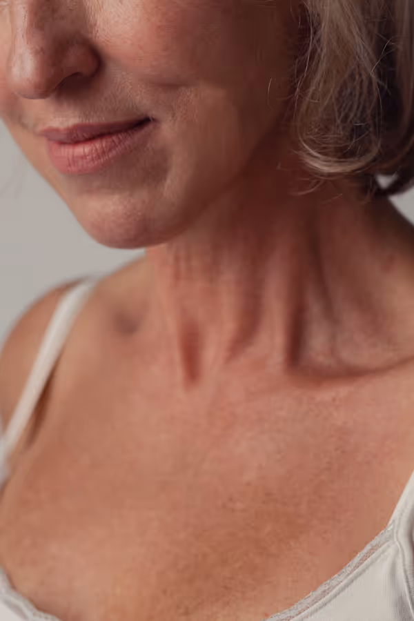 Close-up of a woman’s lower face, neck, and chest