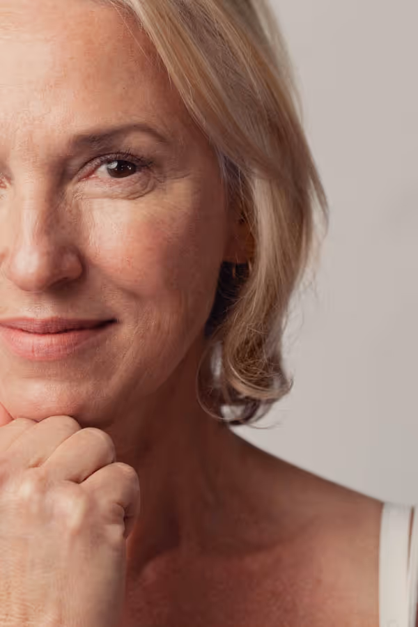 Headshot of half a woman’s face with a fist under her chin