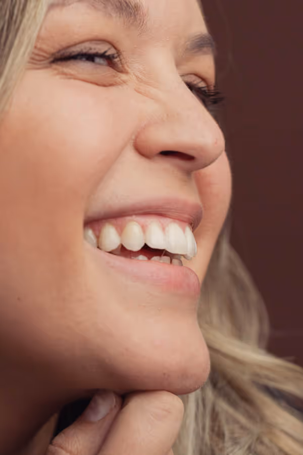 Close-up of one side of the face of a smiling woman with clear skin