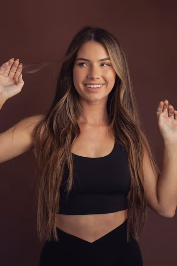 Smiling woman standing with her hands up