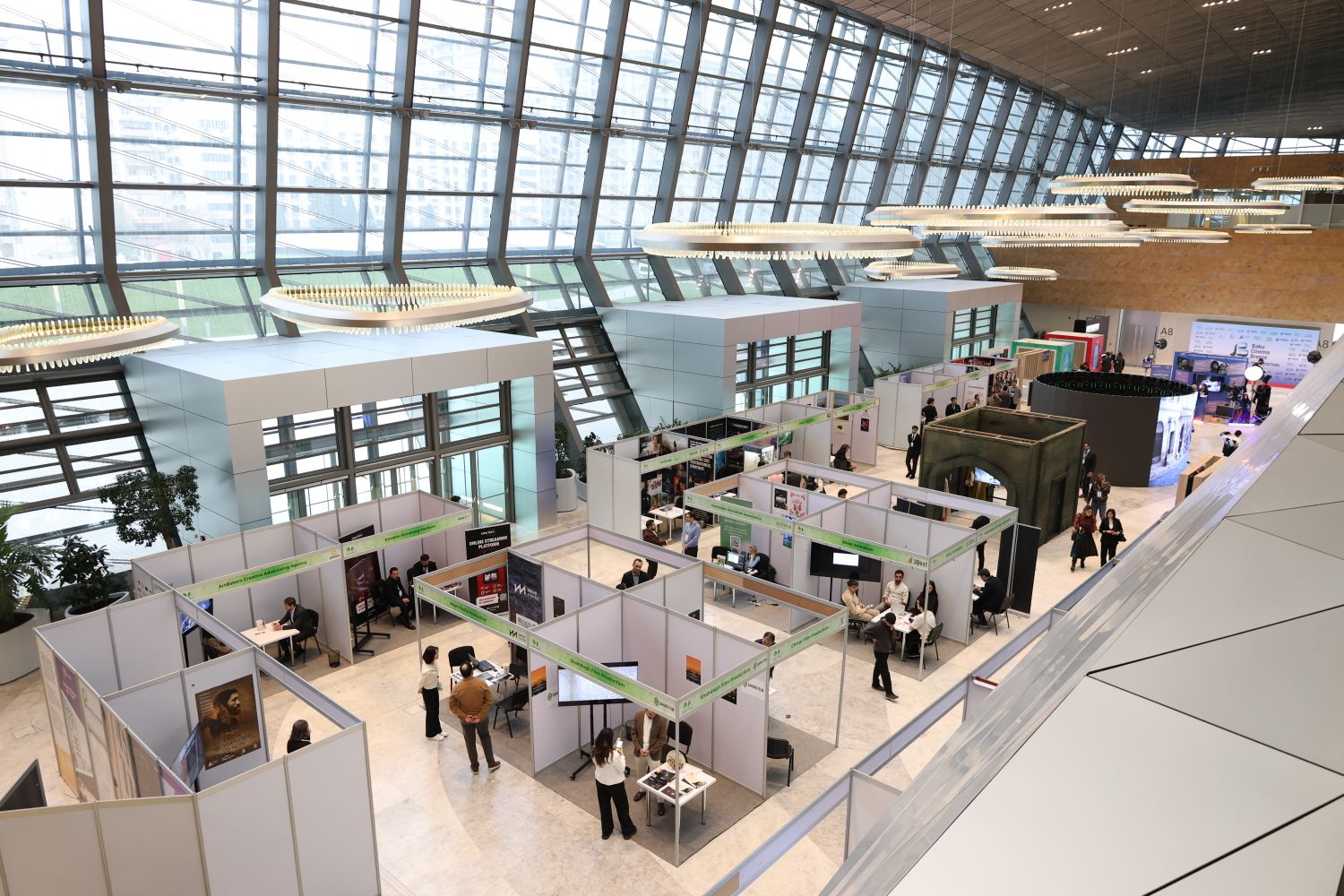 Busy onsite event hall with attendees, exhibitor booths and check-in desks