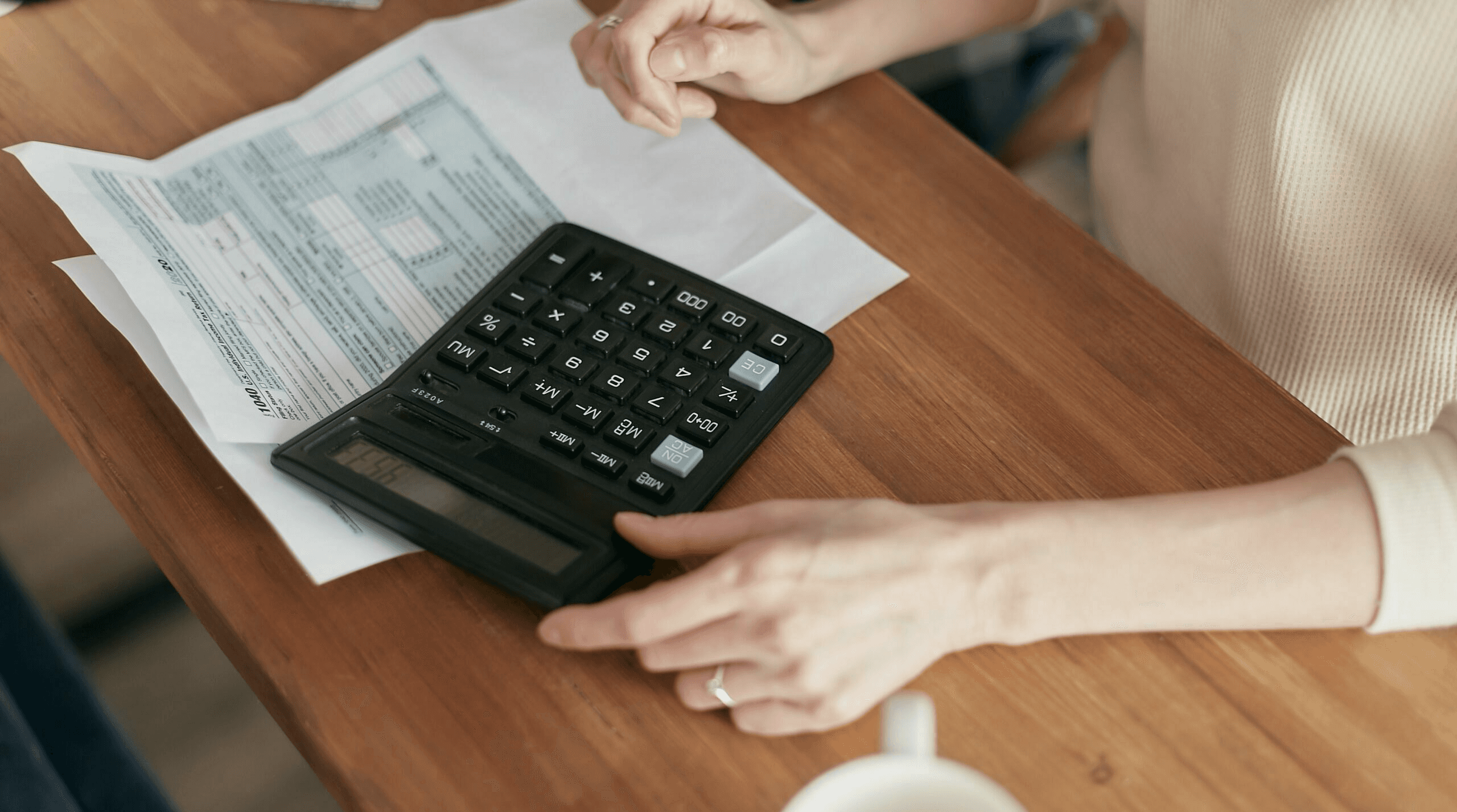  Person uses calculator for forms - Contractor Invoice