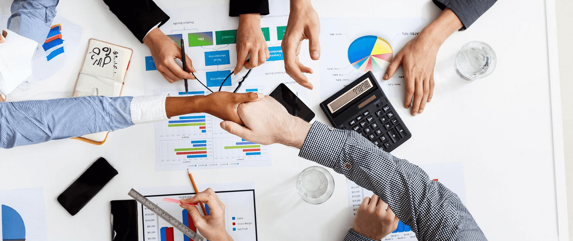 Handshake over business charts - Global Payroll Trends 