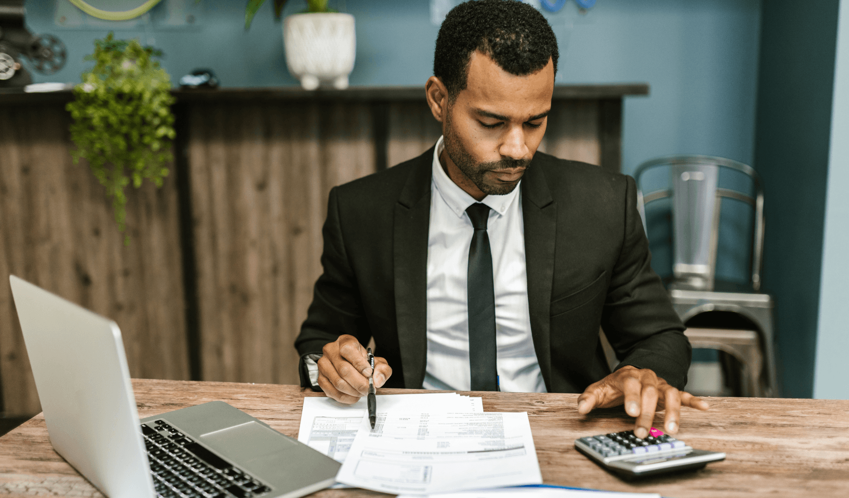 Person using calculator for financial paperwork - Global Payroll Trends 
