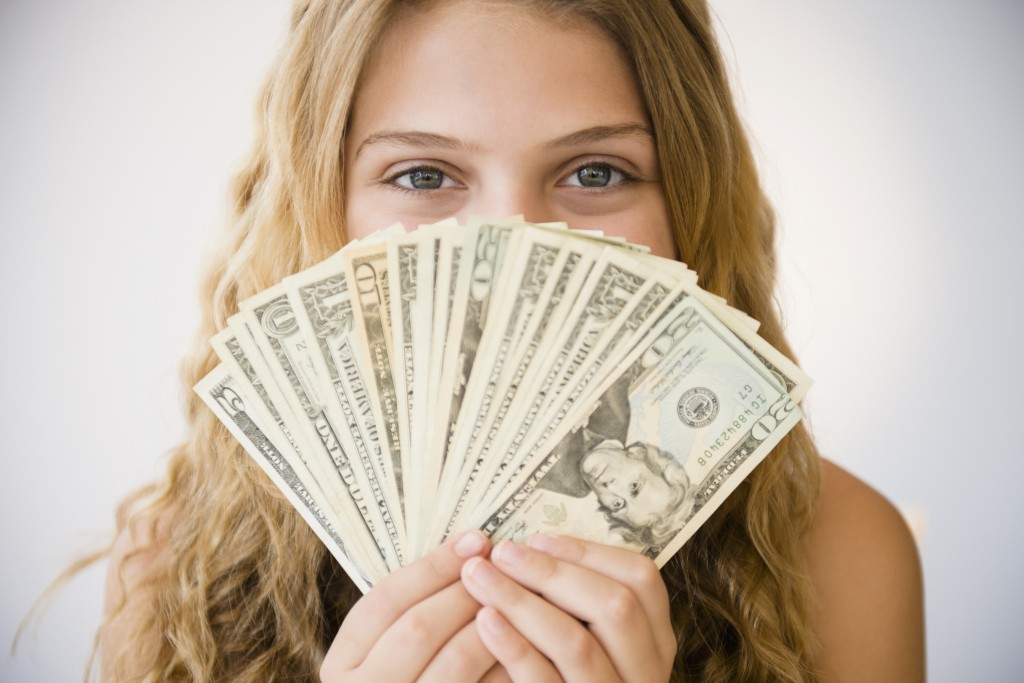 woman holding dollar bills - International Payroll Companies