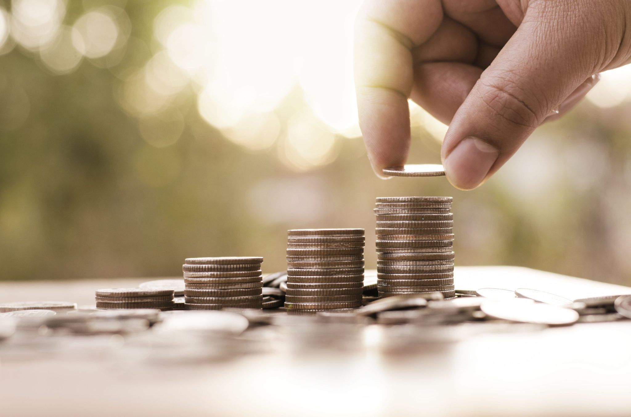 man stacking coins - International Payroll Companies