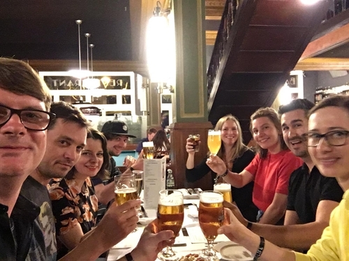 HMI Project team sitting on a table and clinking glasses.