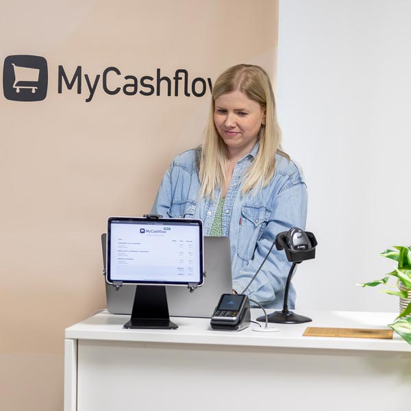 Myymälän tiskillä asiakas on maksamassa ostoksiaan ouhelimen lähimaksulla
