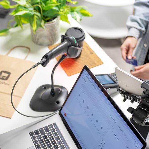 Myymälän tiskillä asiakas on maksamassa ostoksiaan ouhelimen lähimaksulla