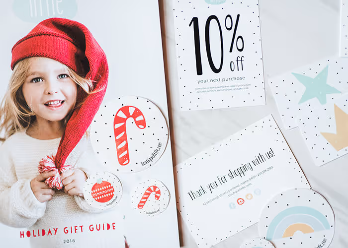Smiling child in red knit hat with holiday gift guide and discount offer