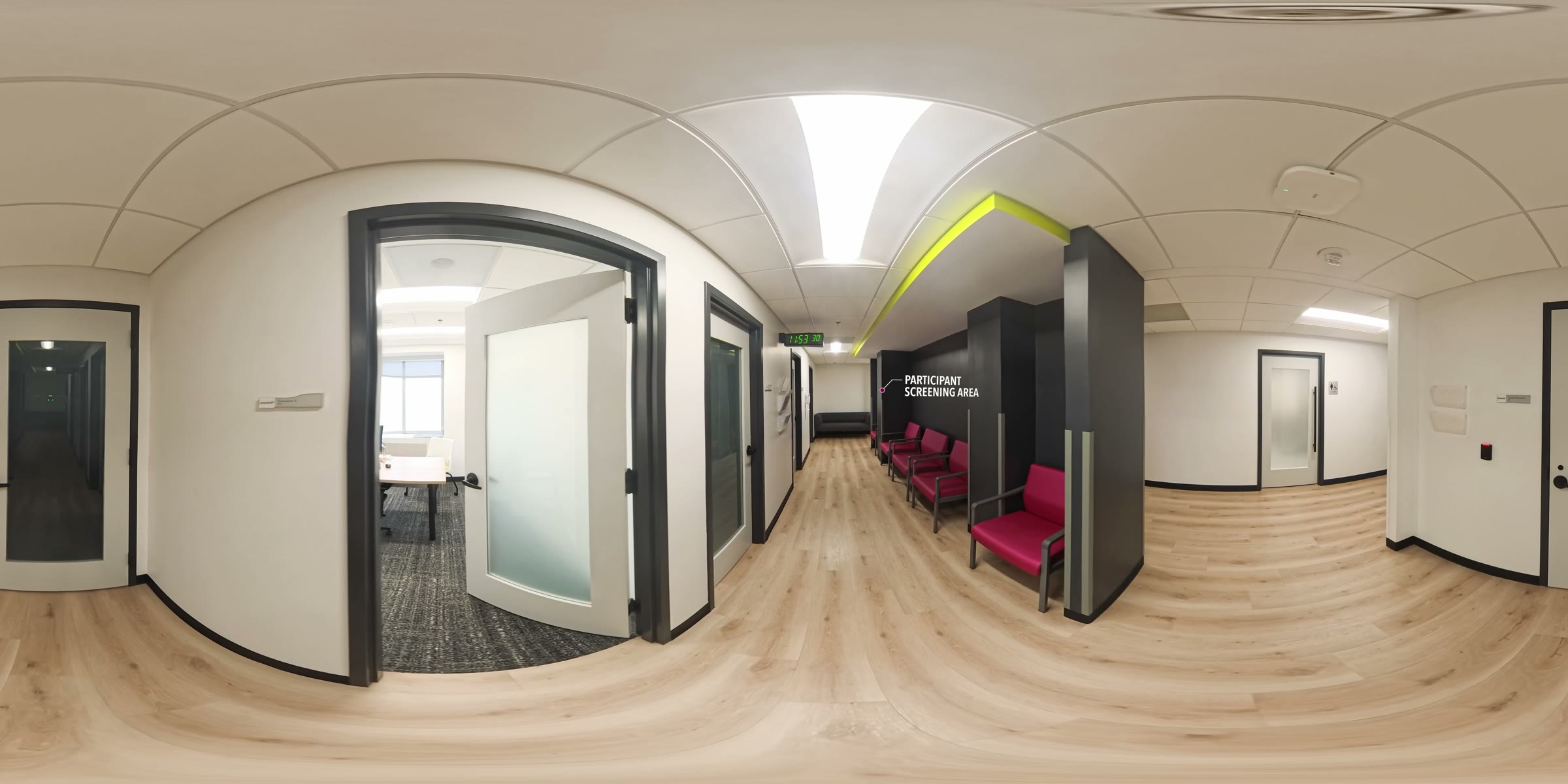 360-degree view of the participant screening area, with wall signage, seating, and glass-paneled offices along the corridor.