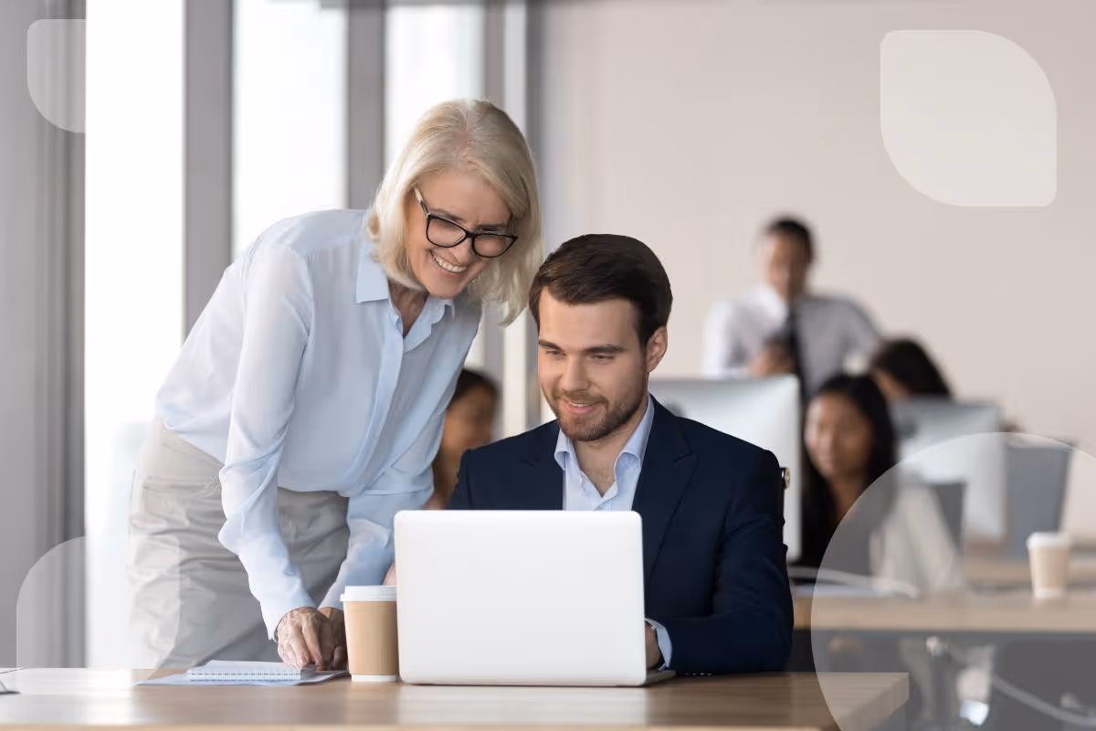 Zwei Kollegen arbeiten gemeinsam an einem Laptop in einem modernen Büro. Sie besprechen vermutlich Datenbanklösungen wie Ninox und FileMaker.