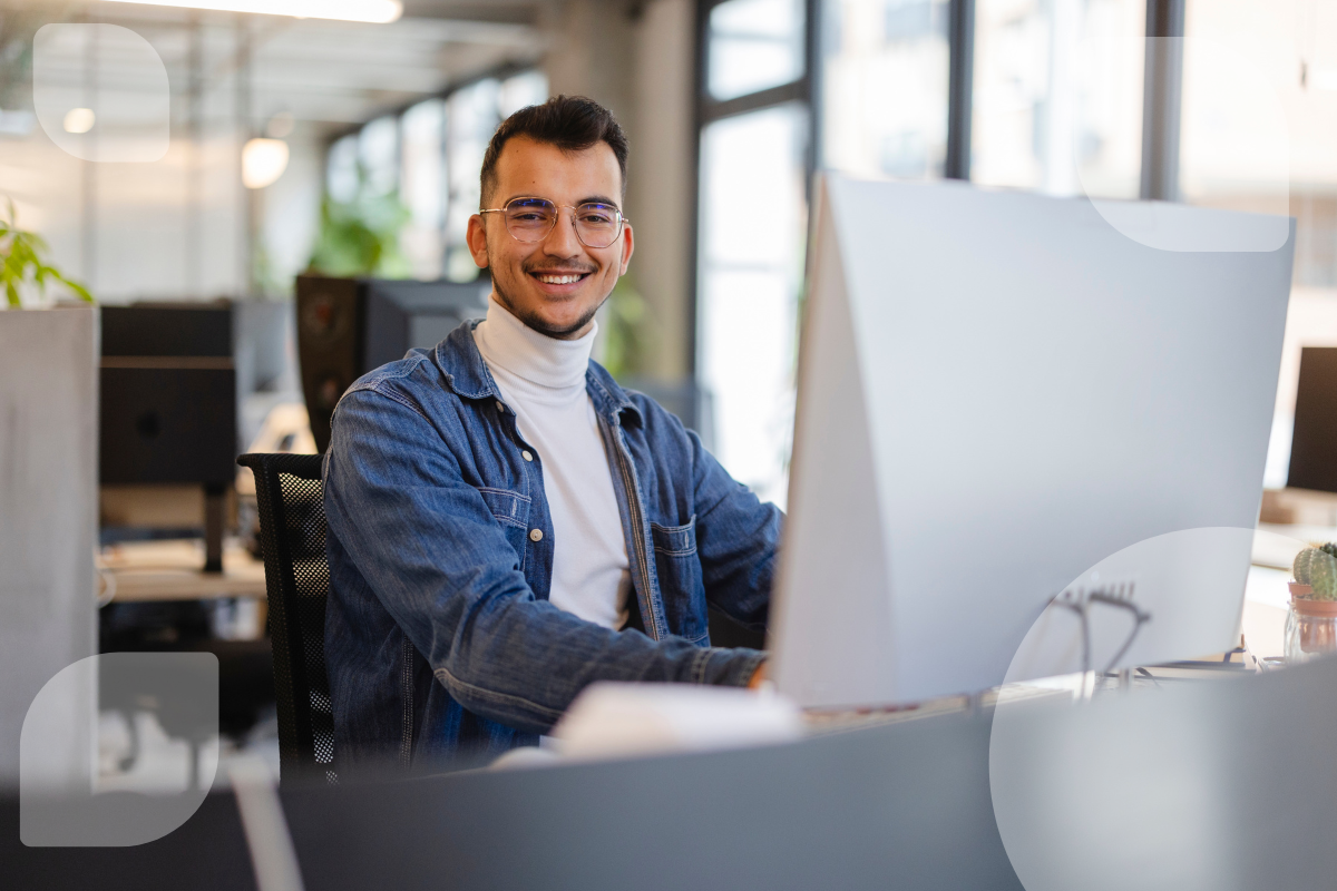 Ein junger Mann arbeitet konzentriert an einem modernen Arbeitsplatz mit großem Monitor. Die Szene vermittelt einen professionellen Eindruck – ideal für eine Airtable Alternative im Büroalltag.