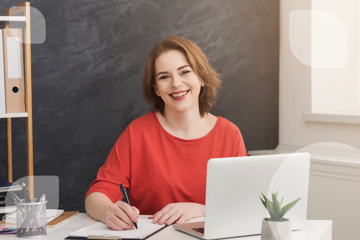 Eine Frau arbeitet lächelnd an einem Schreibtisch mit Laptop und Notizen – symbolisch für den Einsatz von Low-Code in der öffentlichen Verwaltung. Die Technologie unterstützt die Digitalisierung administrativer Prozesse.