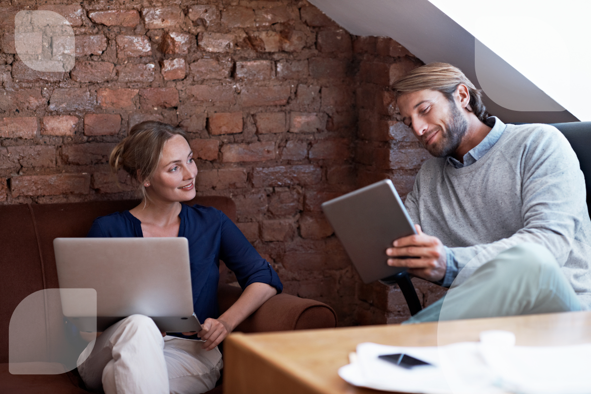 Zwei Personen besprechen digitale Inhalte mit Laptop und Tablet – passend zum Thema ERP System Vergleich. Der Austausch unterstützt die Auswahl passender ERP Software.