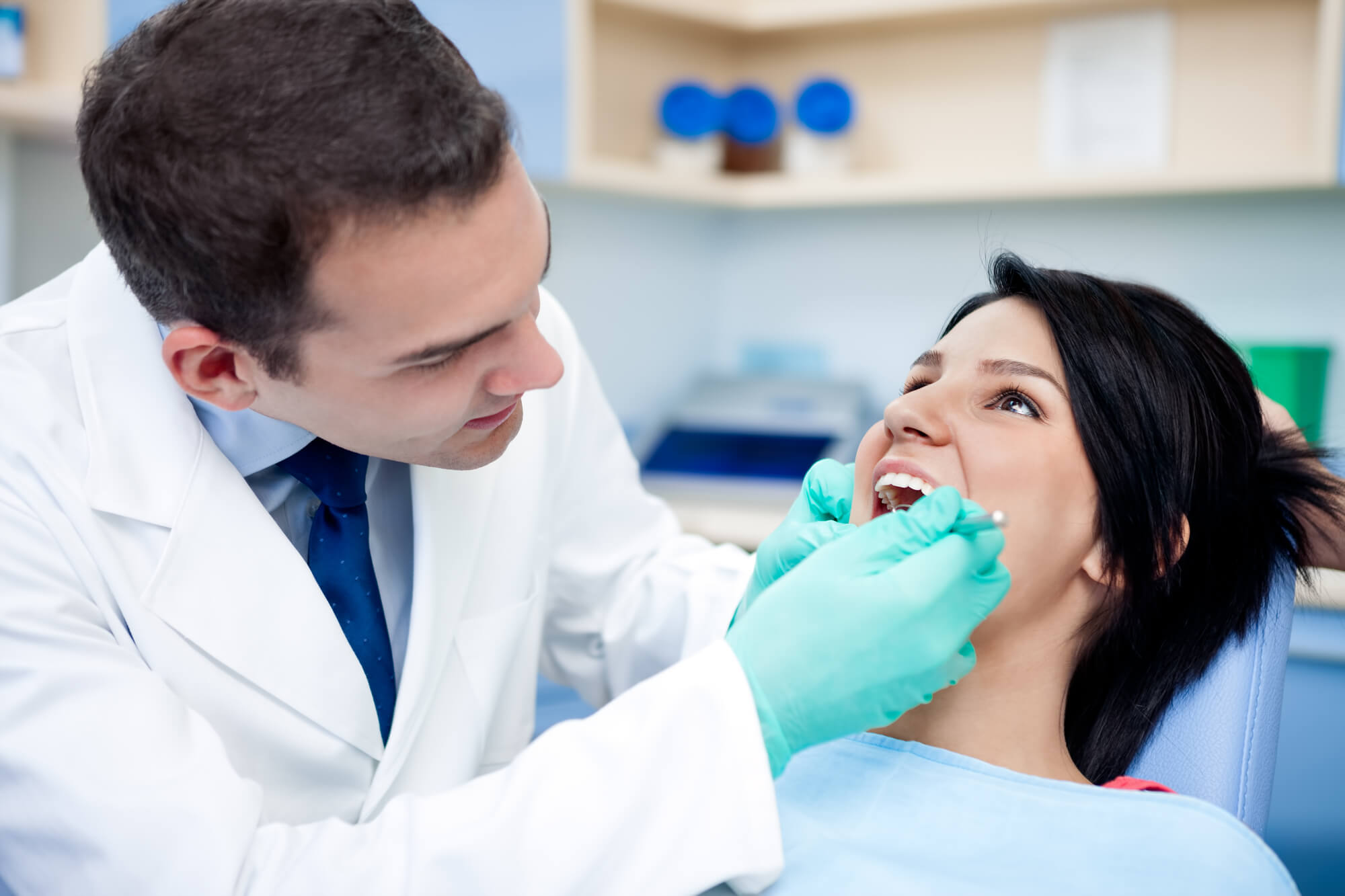 dentist examining a patient's teeth before performing Tooth extractions in Morton, IL