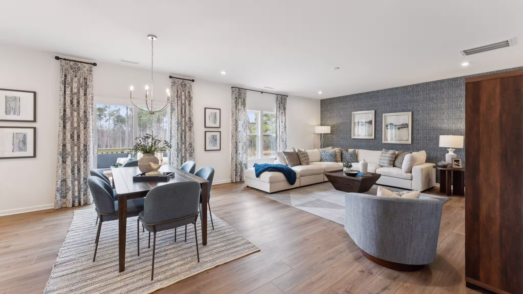 Open floor plan in a single-family home by HHHunt Homes at Charlotte's Ridge featuring a patterned accent wall and large windows