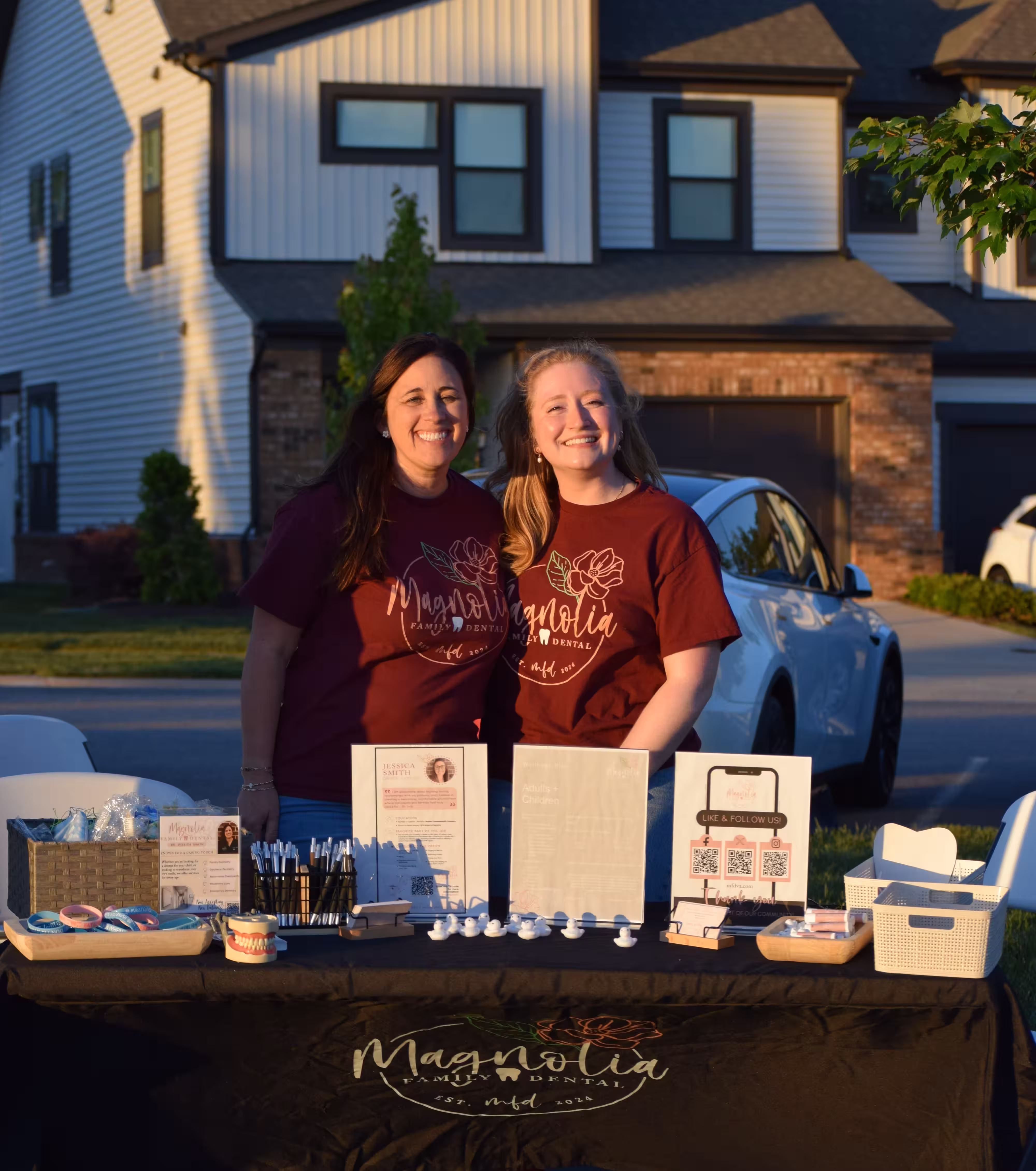 Two girls standing at a table with merchandise from the event