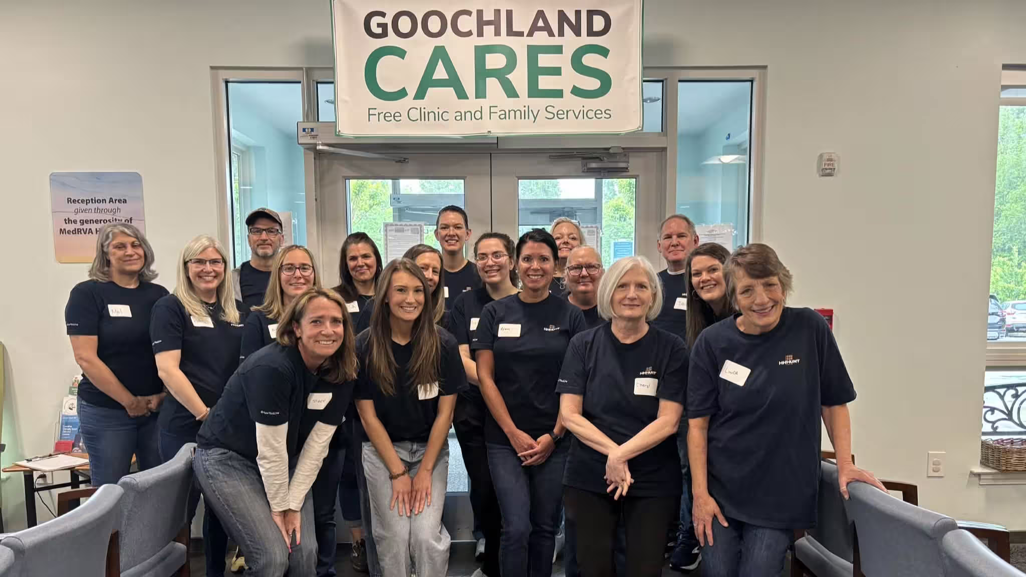 A full team shot of team members wearing matching shirts under a sign that says "Goochland Cares"