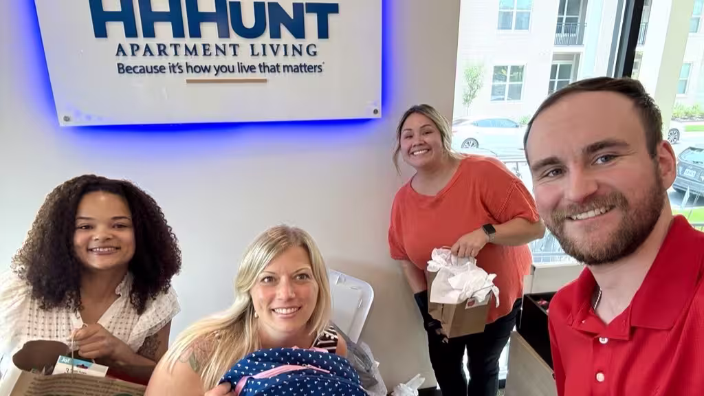 Four people holding school supplies