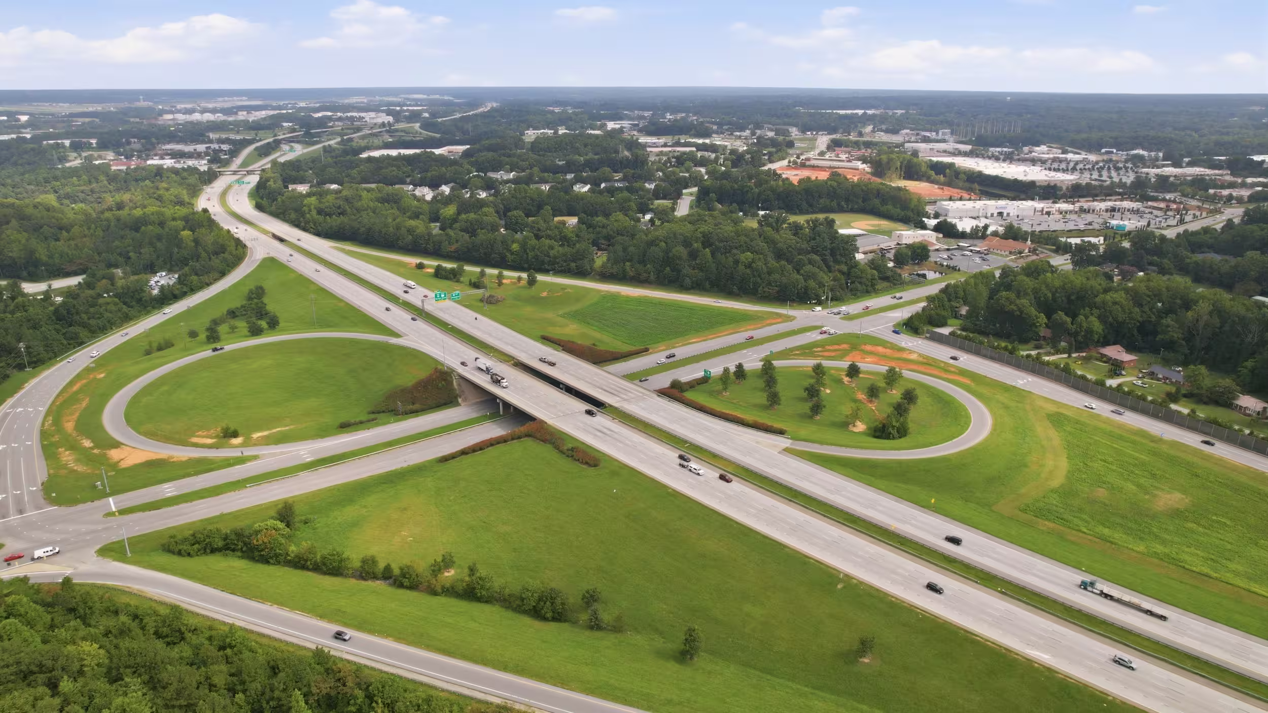a drone shot of a green field with roads, showing the area is cleared.