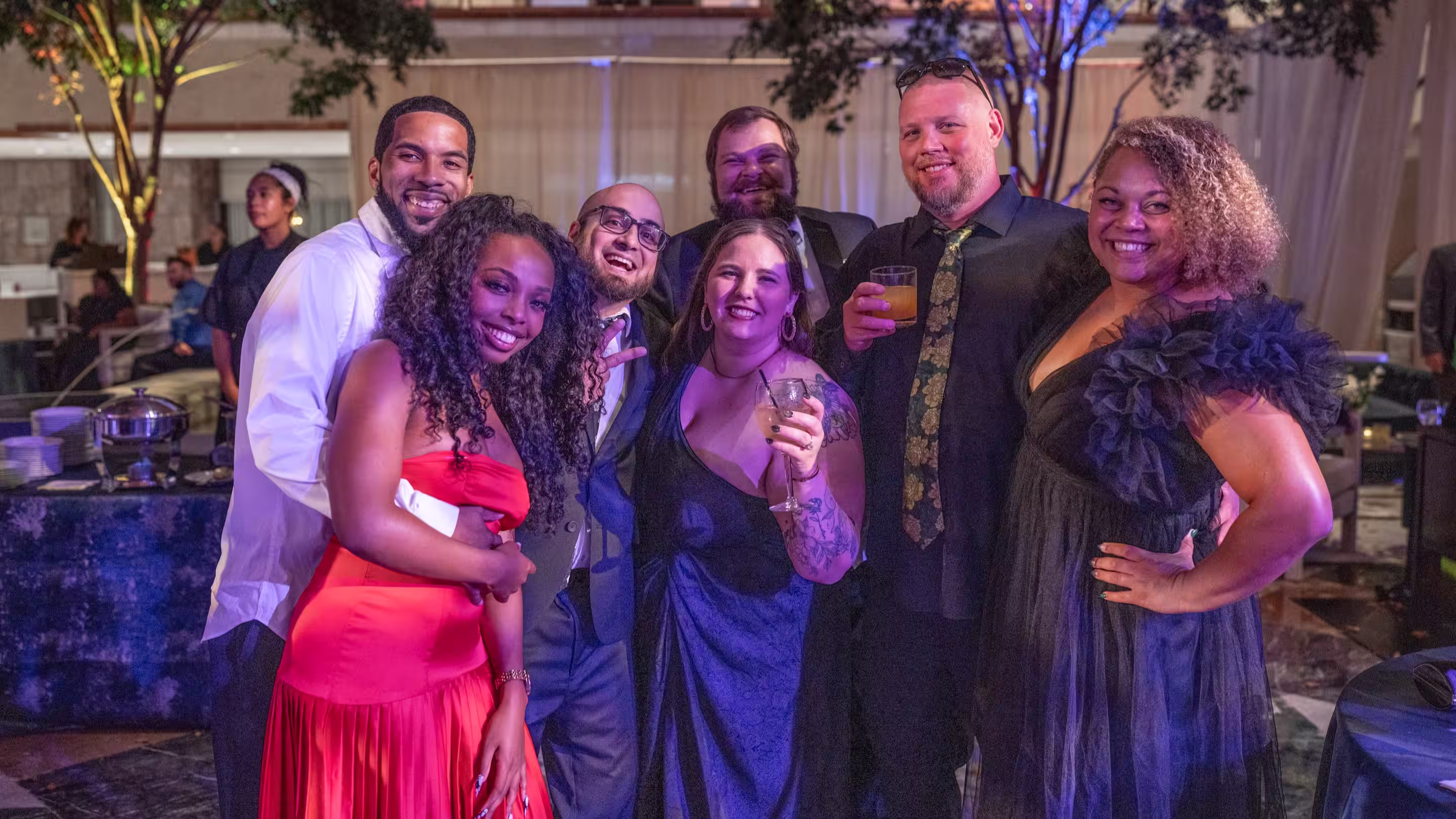 Group of men and women dressed up and posing for a group photo.