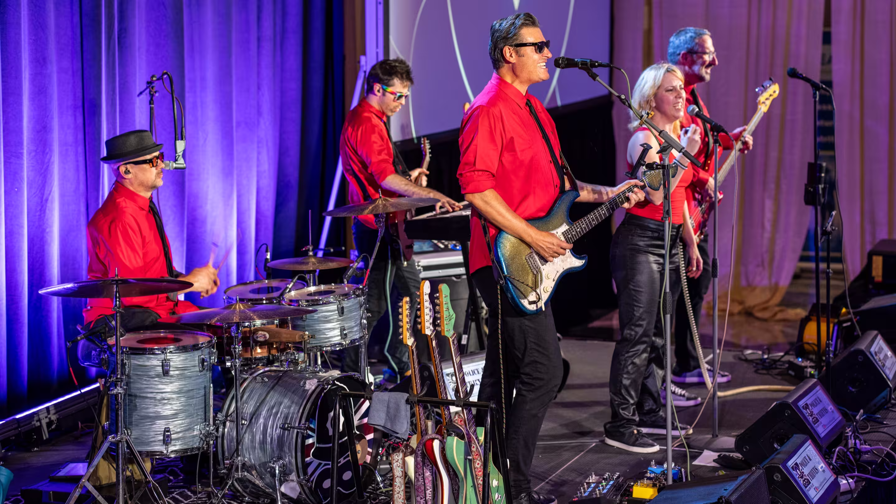 Band in red clothing playing music.