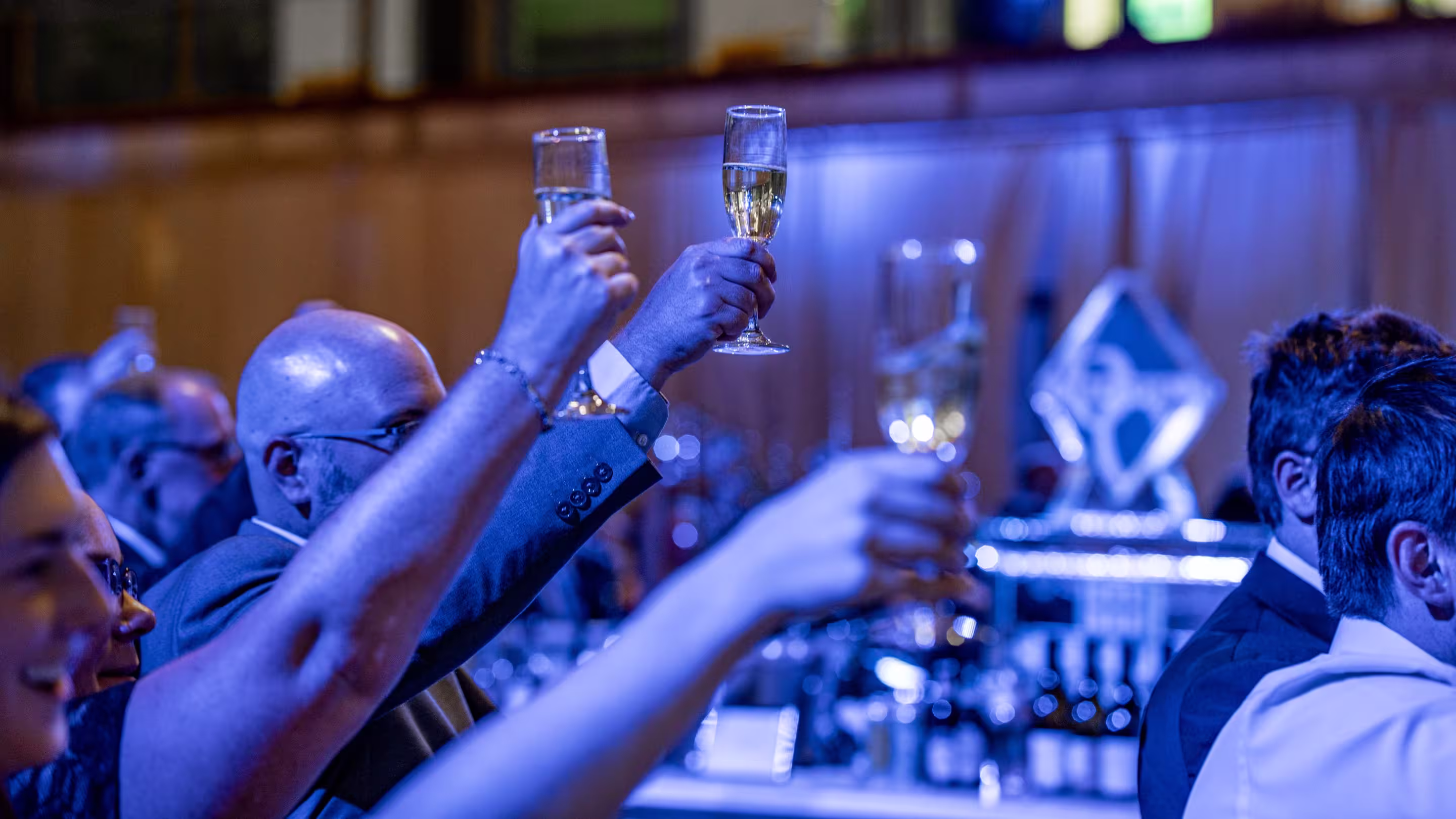 Two people holding glasses to toast.