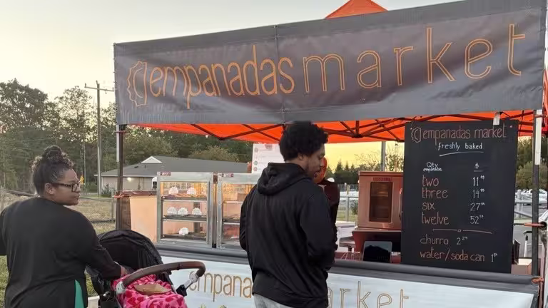 Two people and a baby stroller at a food truck