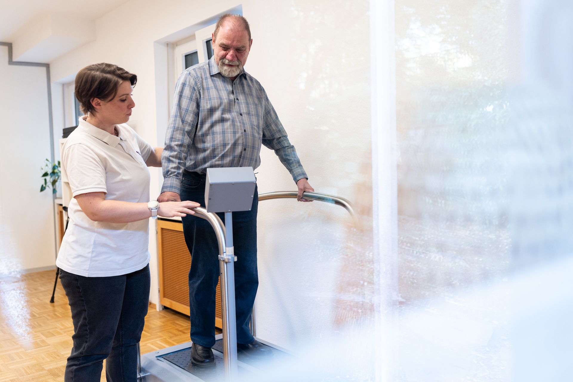 Hand hält ein rundes Holzlabyrinth mit kleinen Metallkugeln als Geschicklichkeitsspiel.