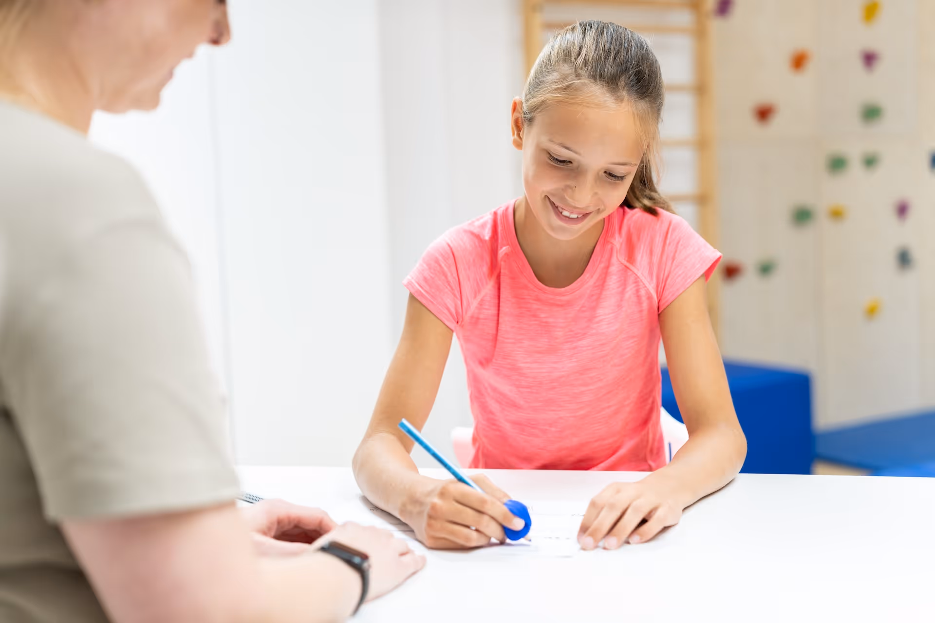 Kind spielt mit buntem Holzspielzeug, das aus Fischen und Stapelringen besteht.