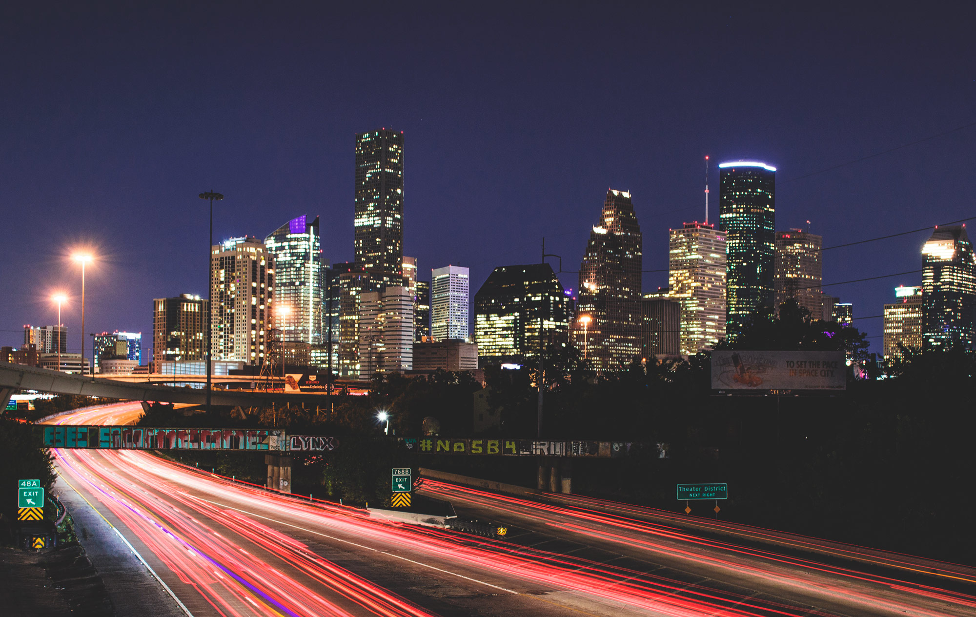 Highway photo outside Houston, blurred taillights leading into the city core