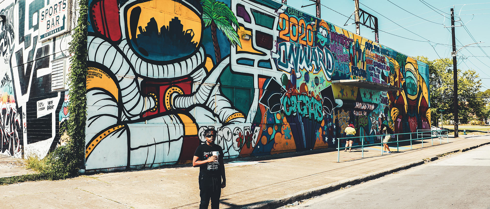 Local youth standing beside Houston graffiti art installation
