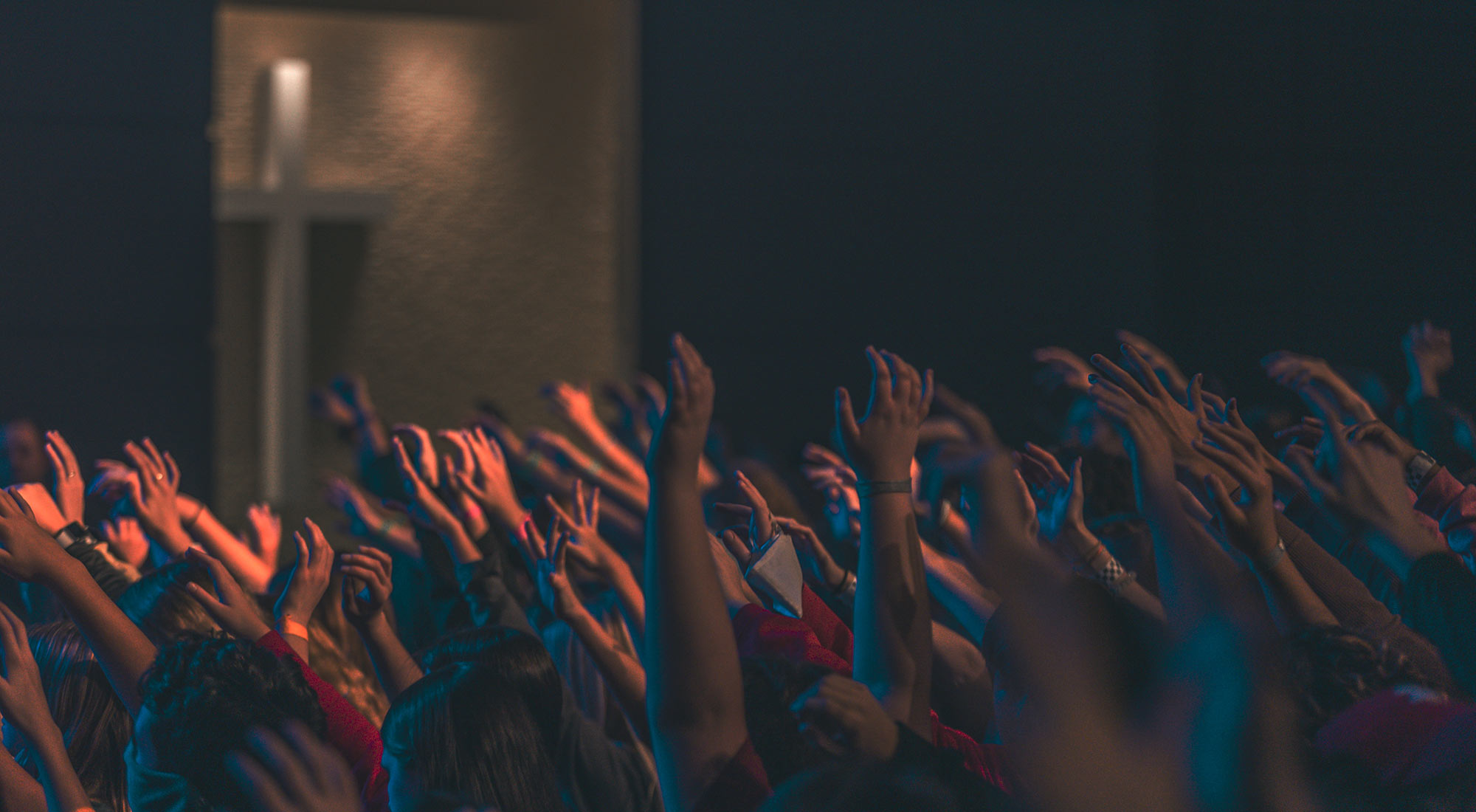 Crowd of people with hands outstretched skyward
