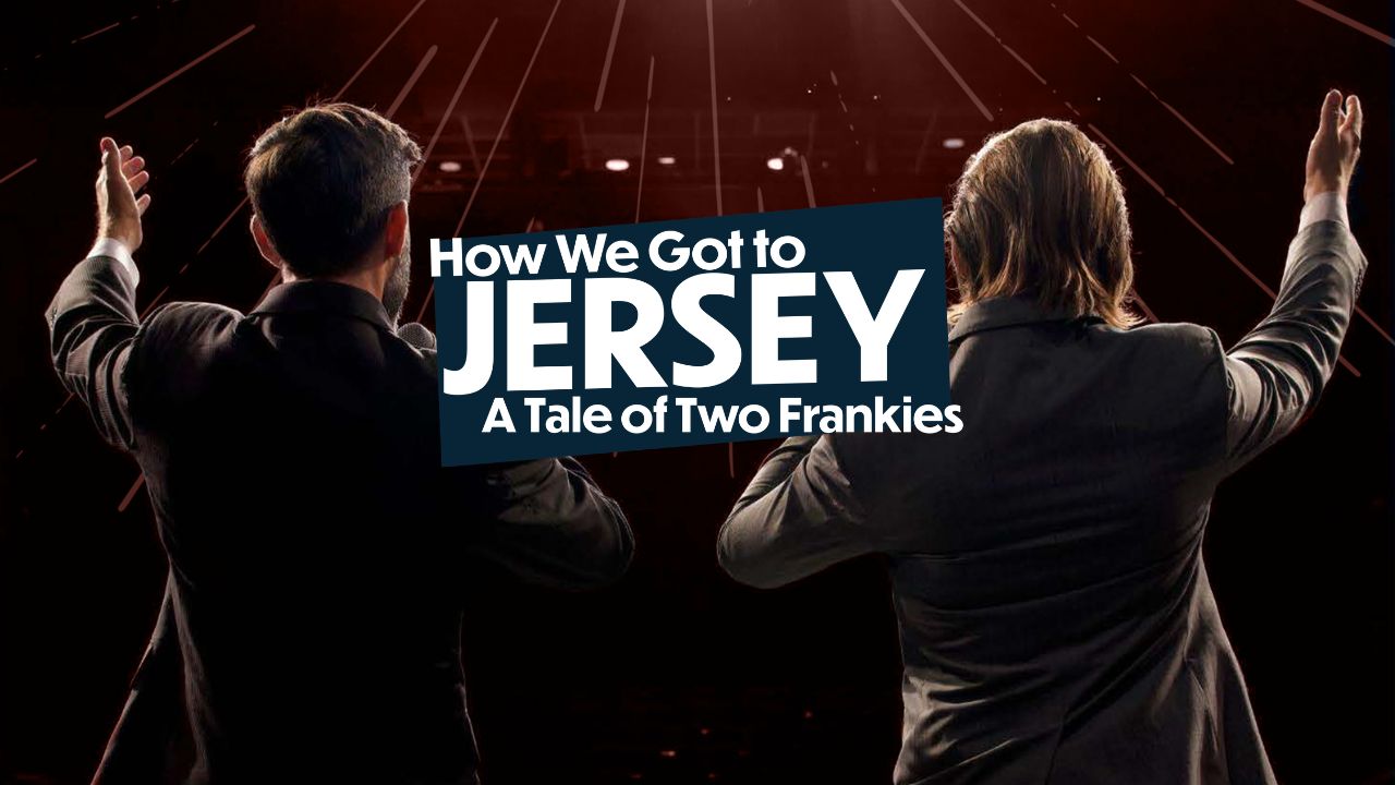 Looking out from the stage, two men performing under stage lights.