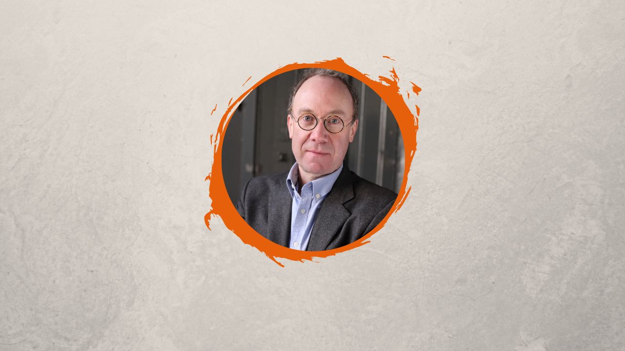 Headshot of author Ben Macintyre on an orange circular background