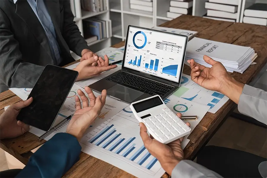 Professional team analyzing financial data with charts on a laptop, crucial for Airbnb property management strategies.