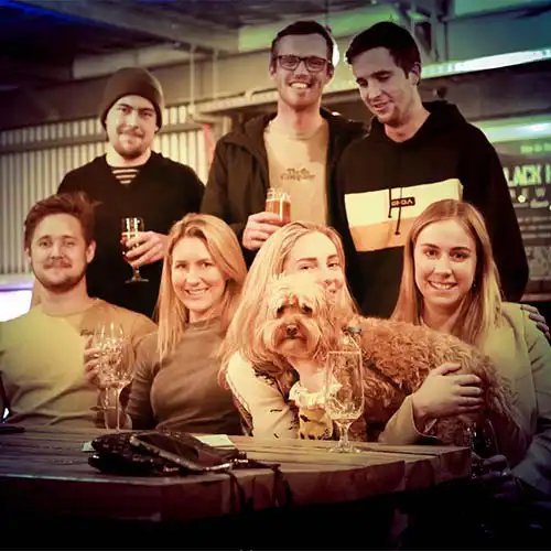 Photo of a team at a Quiz Meisters trivia show holding their dog