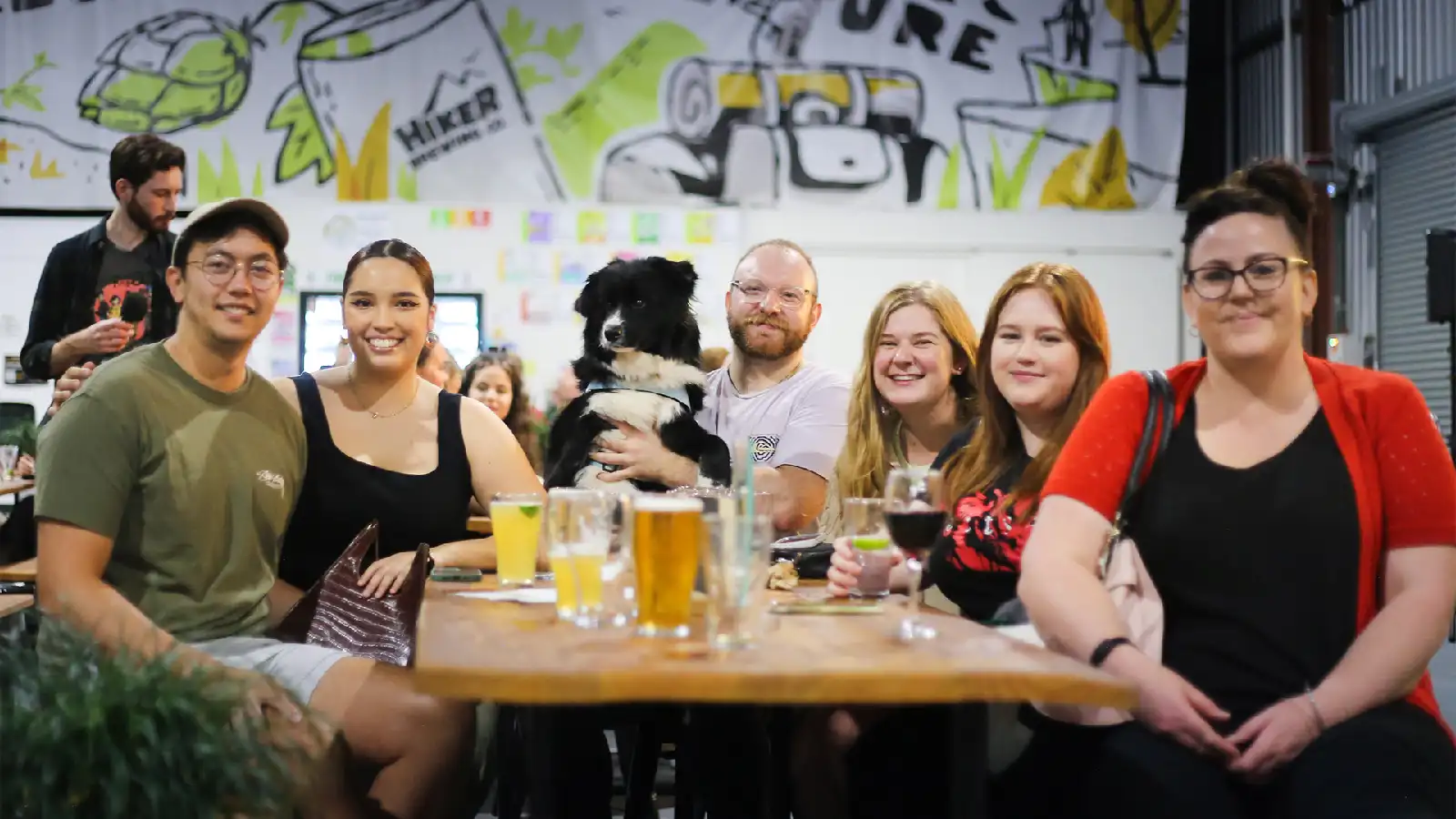 A smiling crowd and dog enjoying a survey says show.