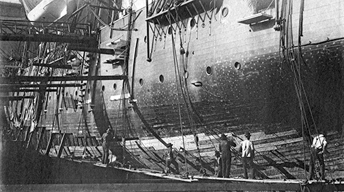Shipyard workers replace the bottom planking of the USS Hartford in Mare Island's Dry Dock No. 1 in 1899.