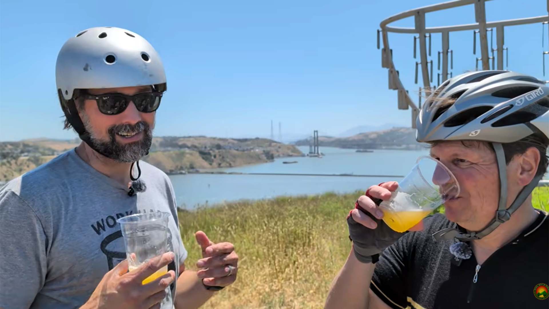 Kent Fortner and Ryan Gibbons in bike helmets holding a can of Saginaw Golden Ale on Mare Island.