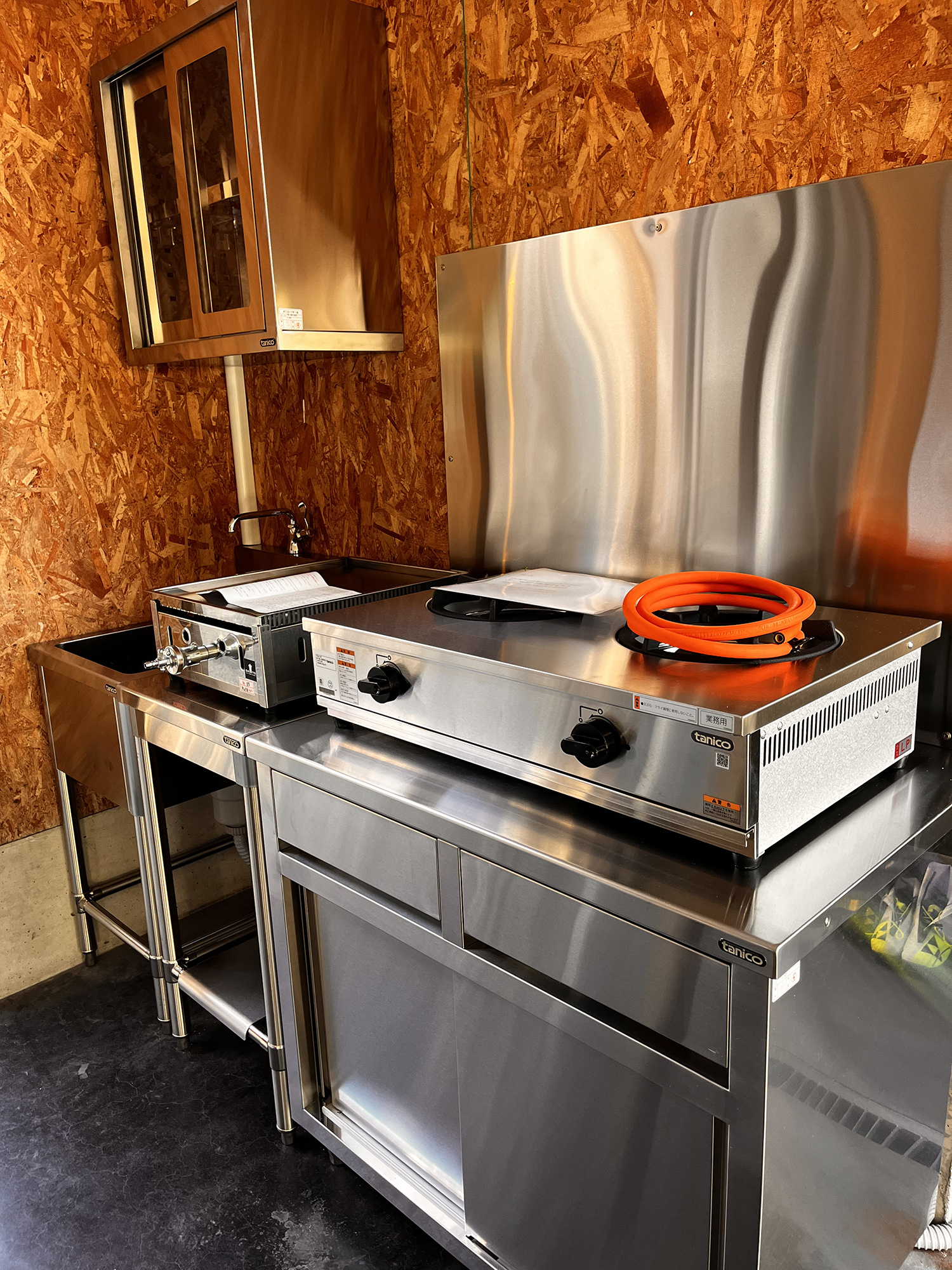 さまざまな電化製品や調理器具（電子レンジ、炊飯器、鍋、ナイフ）を備えたキッチンコーナー