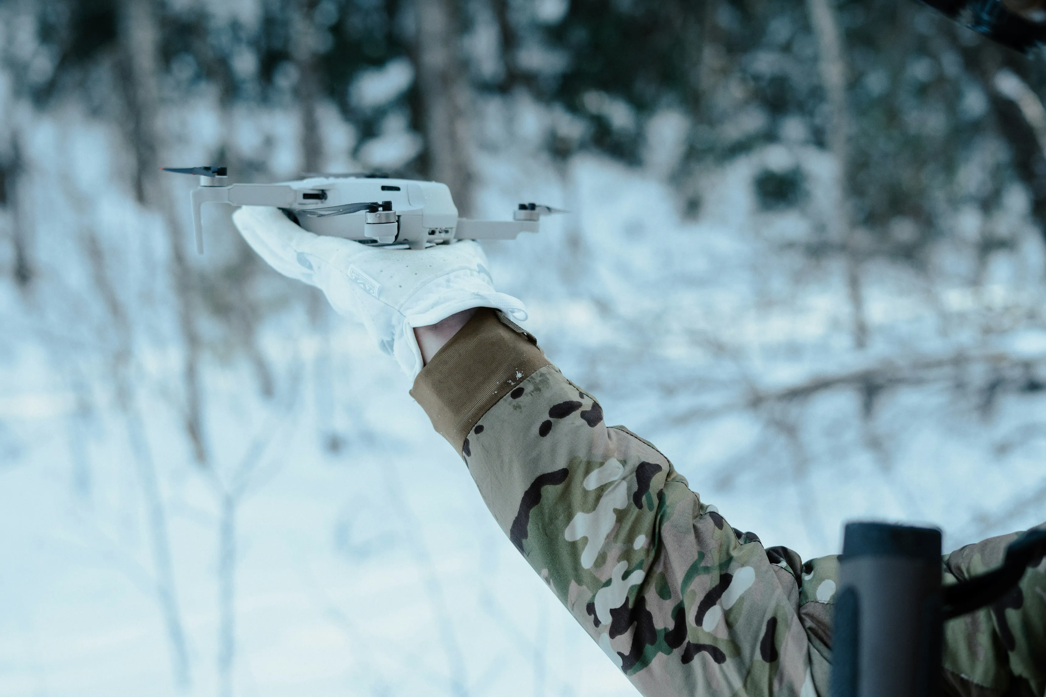 A military man launching a drone from his hand