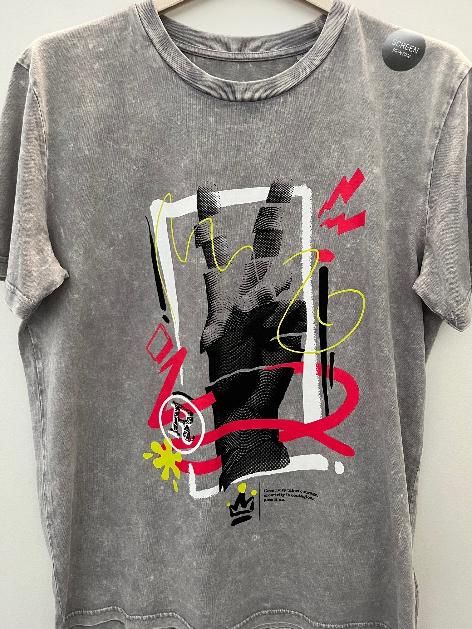 Siebdrucktechnik auf grauem T-Shirt mit farbigem Motiv.