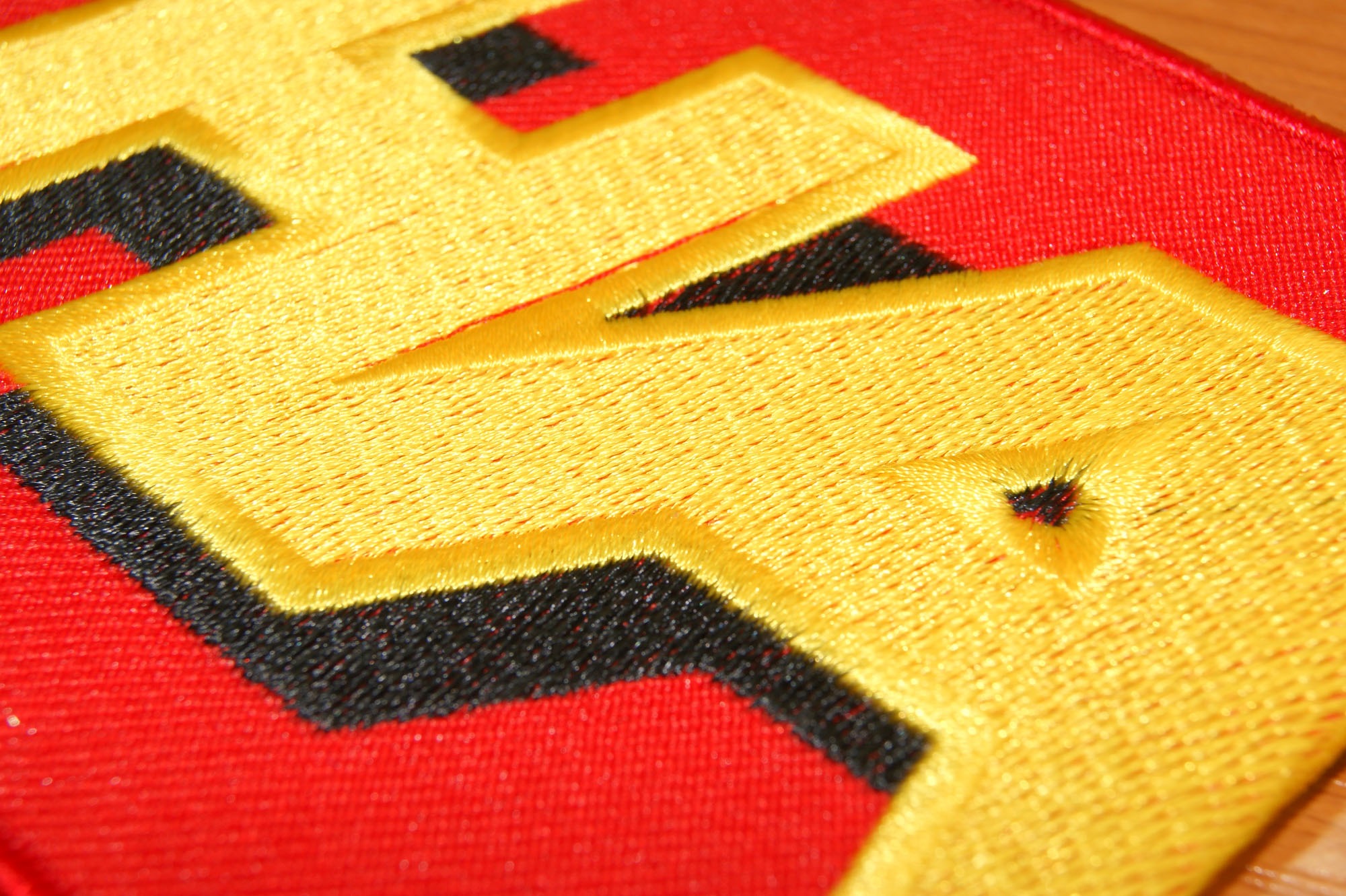 Bestickter Textil mit gelb/schwarzem Stick.