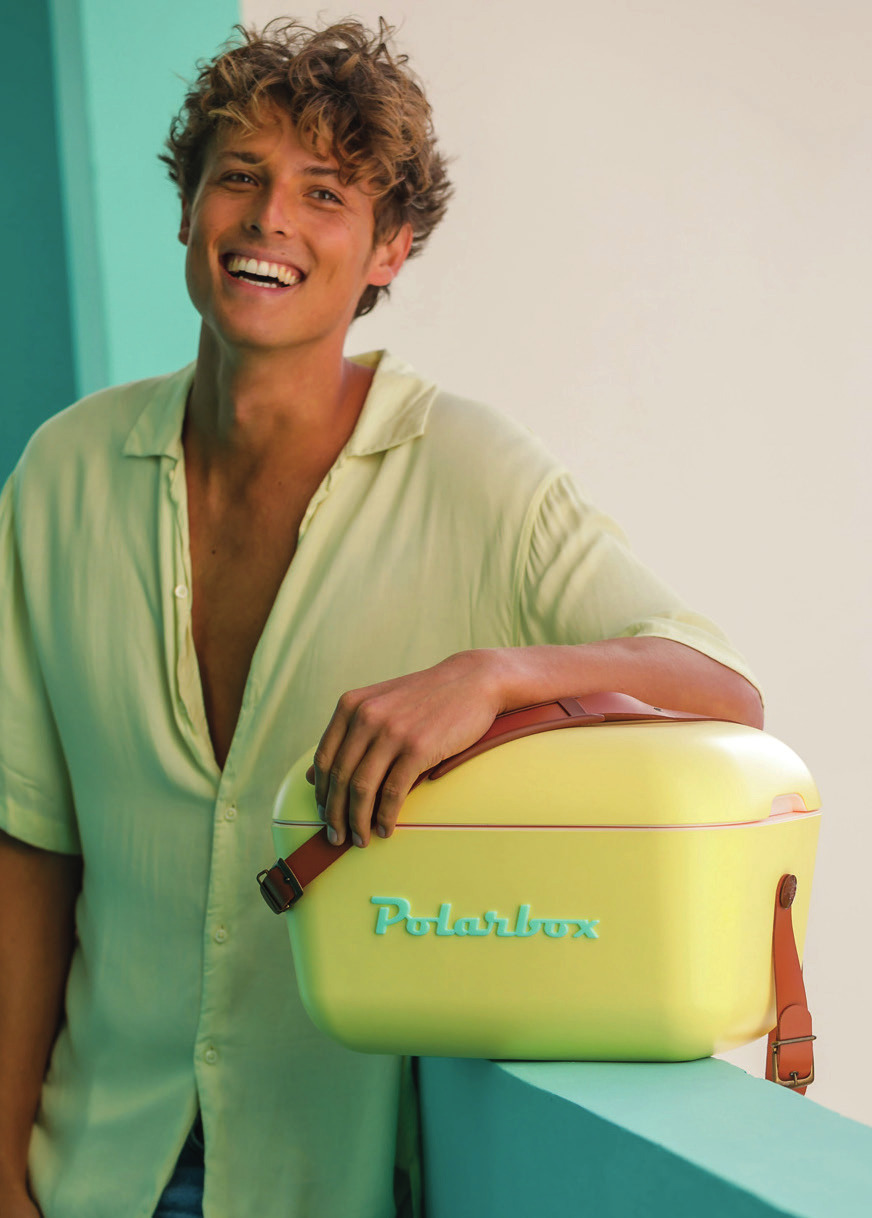Junger Mann trägt eine gelbe Polarbox Retro-Kühlbox mit Lederriemen