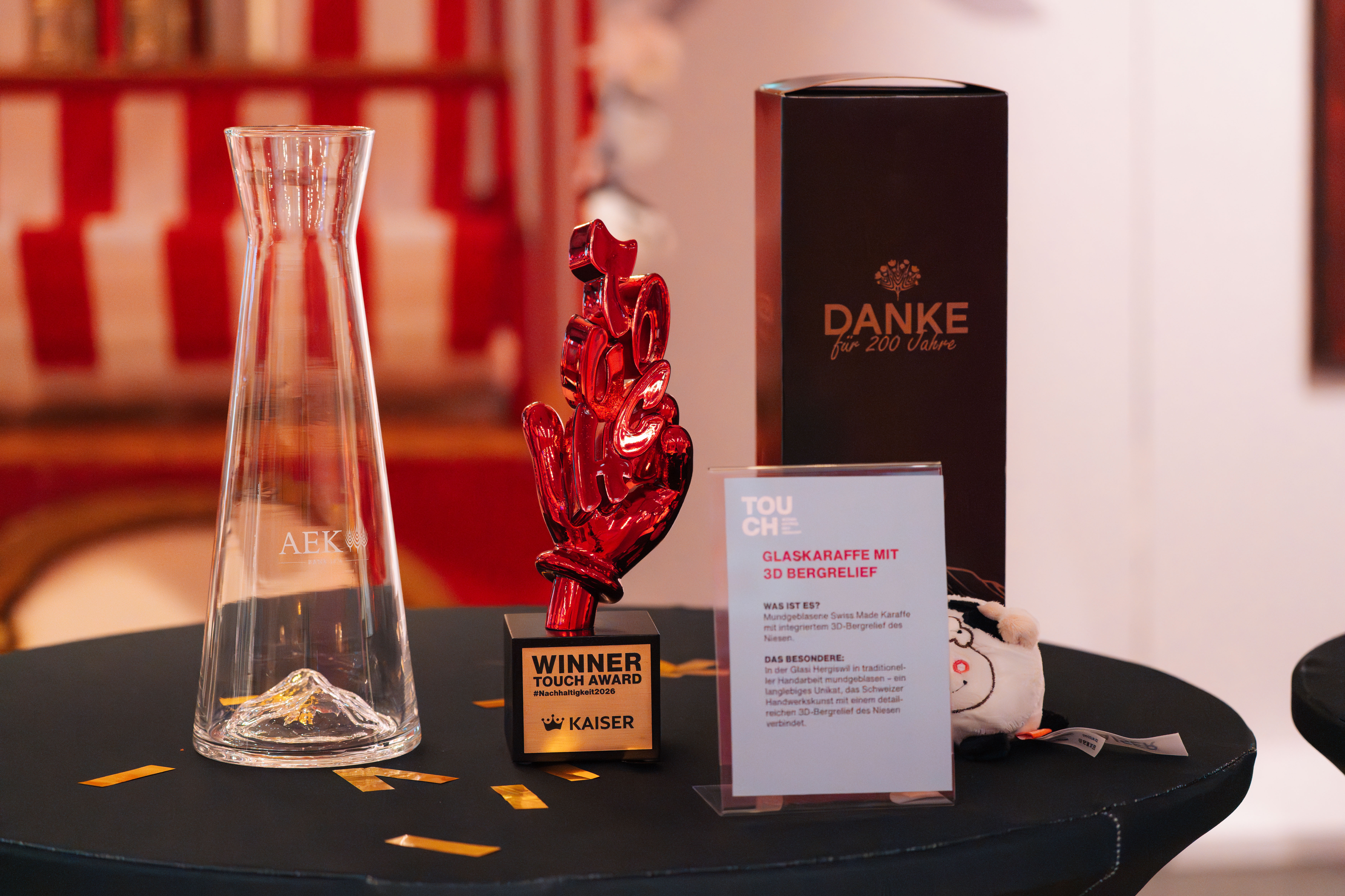 Glaskaraffe mit integriertem Bergrelief, neben dem gewonnen Award.
