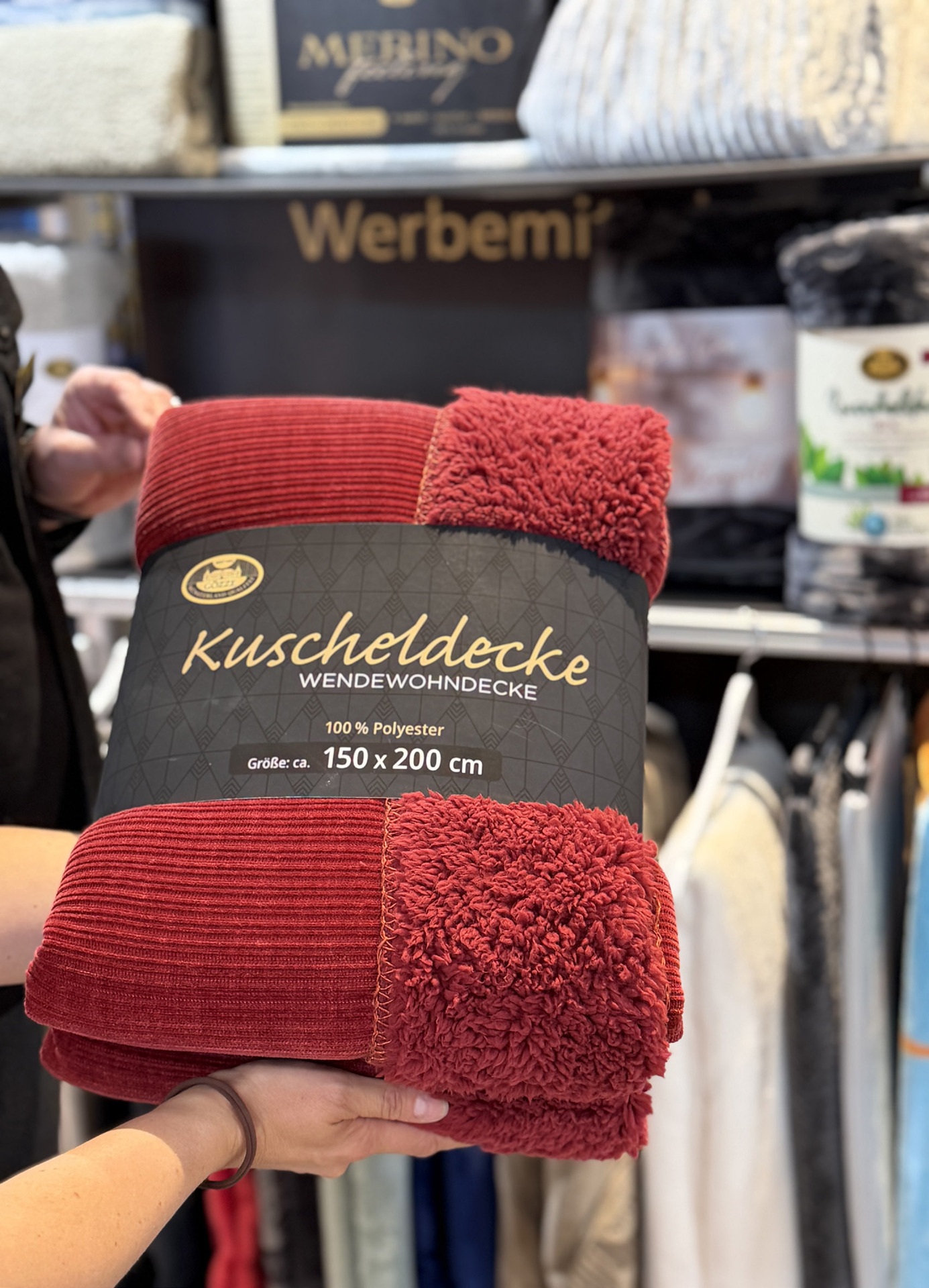 Rote Kuscheldecke LINA mit Cord-Struktur und flauschiger Abseite, gefaltet mit schwarzer Banderole „Kuscheldecke Wendewohndecke 150 x 200 cm“