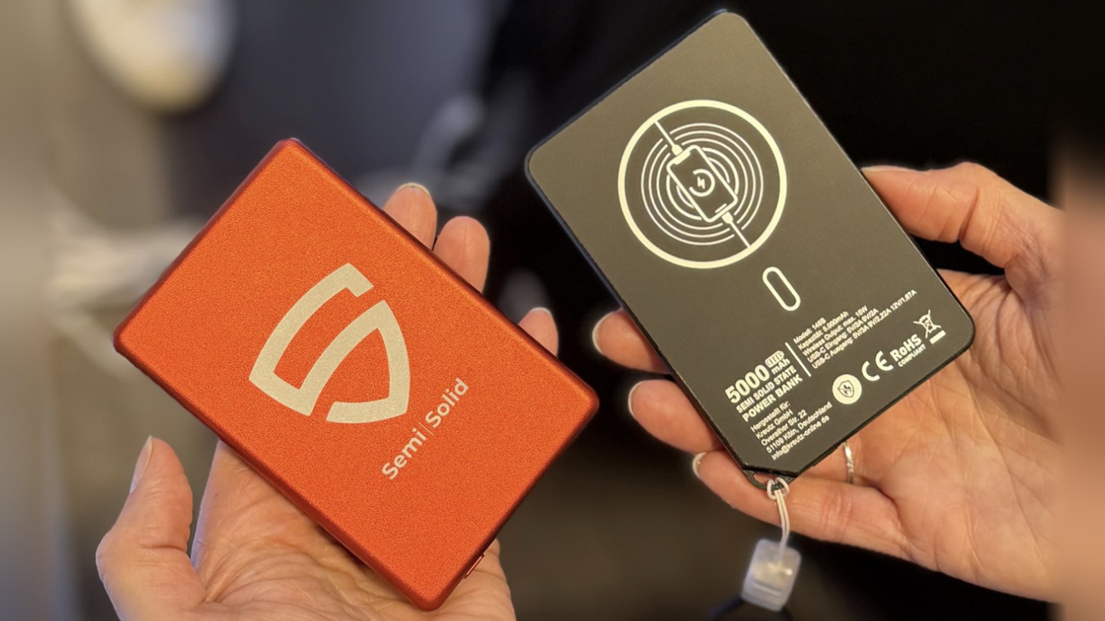 Zwei Powerbanks MagPower Safety mit Semi-Solid-State-Akku in Orange und Schwarz, in den Händen gehalten auf der TOUCH 2026